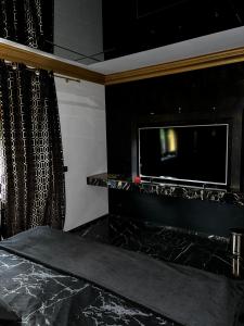 sala de estar con TV y pared negra en LuxuryApartments, en Varsovia