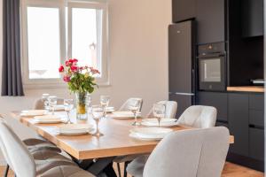 tavolo da pranzo con sedie e vaso di fiori di West Apartments a Zara (Zadar)