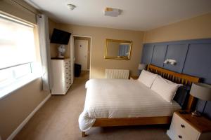 a bedroom with a bed with a blue headboard and a window at Salamander Guest House in Stratford-upon-Avon +18 photos
