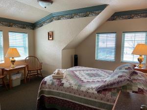 a bedroom with a bed and two windows at Beaver Valley Lodge in Leavenworth