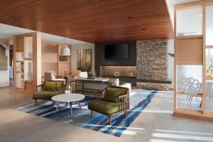 a living room with a fireplace and a table and chairs at Fairfield by Marriott Inn & Suites Middletown in Middletown