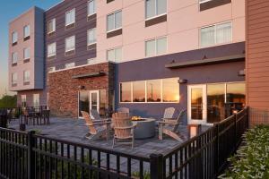 un patio avec des chaises et une table en face d'un bâtiment dans l'établissement Fairfield by Marriott Inn & Suites Middletown, à Middletown