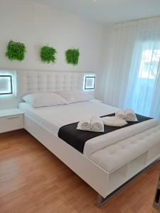 een groot wit bed met 2 handdoeken erop bij Apartman Dawidh in Šibenik