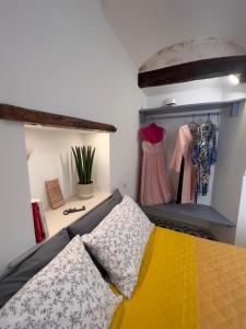 a bedroom with a bed and some dresses on a shelf at Casa Zizì in Locorotondo