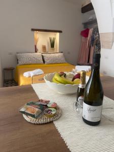 a bottle of wine and a bowl of bananas on a table at Casa Zizì in Locorotondo