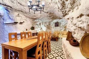 comedor con mesa de madera y sillas en Cueva con jacuzzi a 20 minutos de Valencia, en Benaguacil