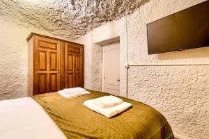 a bedroom with a bed with two towels on it at Cueva con jacuzzi a 20 minutos de Valencia in Benaguacil