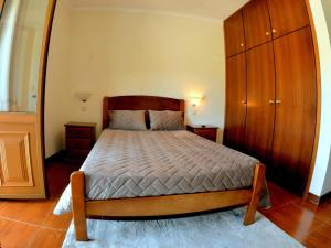 a bedroom with a bed and a wooden cabinet at Menina do Rio in Rio Caldo +12 photos