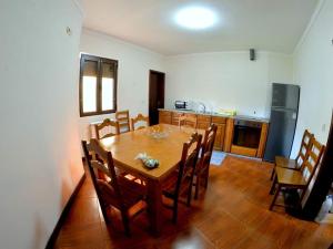 a kitchen with a wooden table and a dining room at Menina do Rio in Rio Caldo