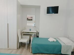 um quarto com uma cama, uma secretária e uma mesa em Le vie del centro em Sciacca