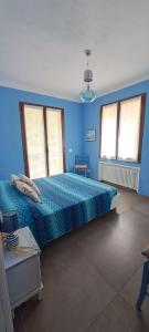 Dormitorio azul con cama grande y edredón azul en La Tillanzia, en Dolceacqua