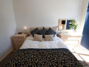 a bedroom with a large bed with blue pillows at Stay Deansgate Apartments for 14 nights plus in Manchester