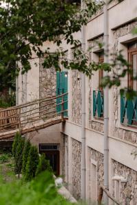 un edificio antiguo con ventanas verdes y una escalera en Valley Park Dilijan, en Dilijan