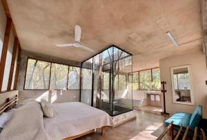 a bedroom with a bed and a large window at El Encanto - Hotel Boutique in Chichén-Itzá