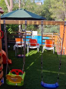 a swing set with chairs and a gazebo at Relax House Barcelone in Sant Esteve Sesrovires