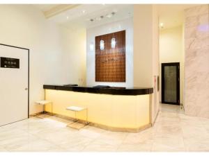 un vestíbulo con un mostrador con 2 bancos en una habitación en QUEEN'S HOTEL CHITOSE - Vacation STAY 67737v en Chitose