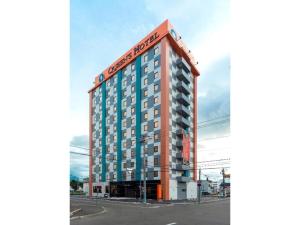 un edificio alto con un cartel encima en QUEEN'S HOTEL CHITOSE - Vacation STAY 67737v en Chitose