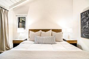 a bedroom with a large white bed with two lamps at Dune House in Manistee