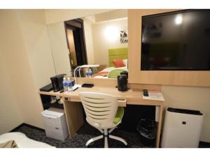 a room with a desk with a chair and a television at QUEEN'S HOTEL CHITOSE - Vacation STAY 67738v in Chitose +18 photos