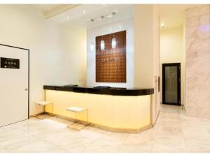 a lobby with a counter with two benches in a room at QUEEN'S HOTEL CHITOSE - Vacation STAY 67738v in Chitose