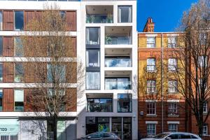 an apartment building with trees in front of it at Trendy Kings Cross Flat in London