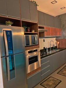 a kitchen with a stainless steel refrigerator and cabinets at Casa Paradise Mogi in Mogi das Cruzes