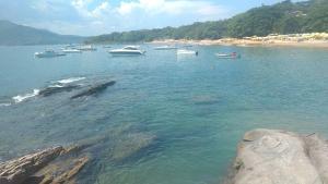 a group of boats in the water near a beach at Chalés da Barra Ilhabela in Ilhabela