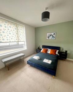 a bedroom with a blue bed and a window at Modern, comfy 2 bedroom flat in Hatfield town centre in Hatfield