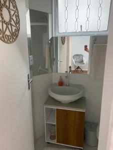 W łazience znajduje się umywalka i lustro. w obiekcie Confortável Apartamento em Bagé w mieście Bagé
