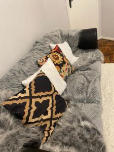 Confortável Apartamento em Bagé في باخي: سرير عليه وسائد وبطانية رمادية