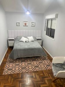 a bedroom with a bed and a rug at Confortável Apartamento em Bagé in Bagé