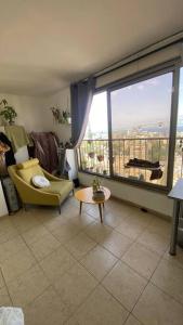 a living room with a yellow chair and a large window at Sea view apartment in Haifa