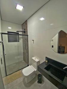 a bathroom with a shower and a toilet and a mirror at Casa Paradise Mogi in Mogi das Cruzes