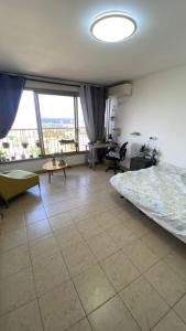 a bedroom with a bed and a large window at Sea view apartment in Haifa