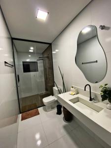 uma casa de banho com um lavatório, um WC e um espelho. em Casa Paradise Mogi em Mogi das Cruzes