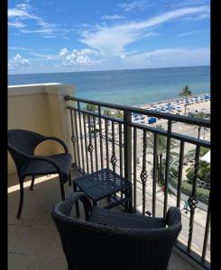 a balcony with chairs and a view of the beach at The Atlantic Hotel & Spa Condo in Fort Lauderdale