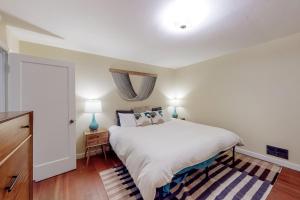 Un dormitorio con una gran cama blanca y una ventana. en Rooster Cottage, en Healdsburg