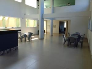 a room with tables and chairs in a building at Flats da Júnia - ótimo beneficio com wifi, ar, tv, frigobar in Lagoa Santa +4 photos