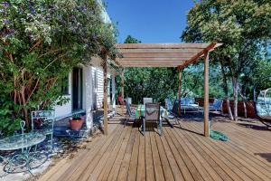 una terraza de madera con pérgola, mesa y sillas en Rooster Cottage, en Healdsburg