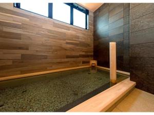 a bathroom with a shower with a wooden wall at QUEEN'S HOTEL CHITOSE - Vacation STAY 67734v in Chitose
