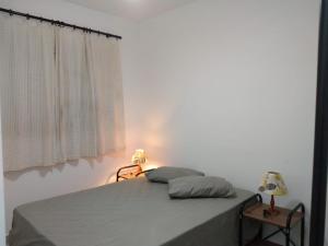 a bedroom with a bed with two pillows and a window at Aconchegante Apto Praia do Centro in Itanhaém +85 photos