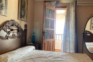 ein Schlafzimmer mit einem Bett und eine Tür mit einem Fenster in der Unterkunft casa vacacional in Almonte