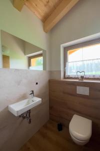 a bathroom with a sink and a toilet and a window at Ferienwohnung am Bauernhof, Korbingerhof in Rinn