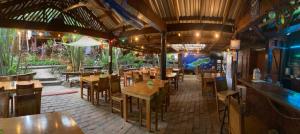 un restaurante con mesas y sillas y un bar en Mango Inn Resort, en Utila