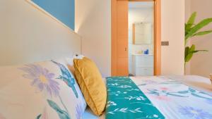 a bedroom with a bed with a yellow pillow on it at Casa Vestali in Granada