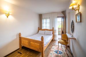 een slaapkamer met een bed, een stoel en een raam bij Four Riders Guest House in Veliko Tŭrnovo