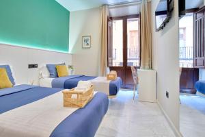 ein Hotelzimmer mit 2 Betten und einem Balkon in der Unterkunft Casa Vestali in Granada