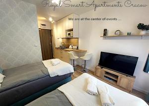 a hotel room with two beds and a flat screen tv at Royal Smart Apartments Cracow in Kraków
