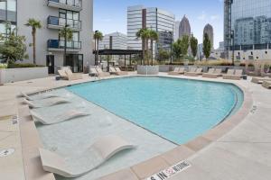 a large swimming pool with lounge chairs and a building at Midtown Luxury Apartment in Atlanta