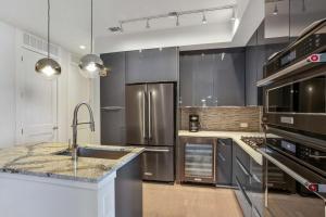 una cocina con electrodomésticos de acero inoxidable y fregadero en Midtown Luxury Apartment en Atlanta